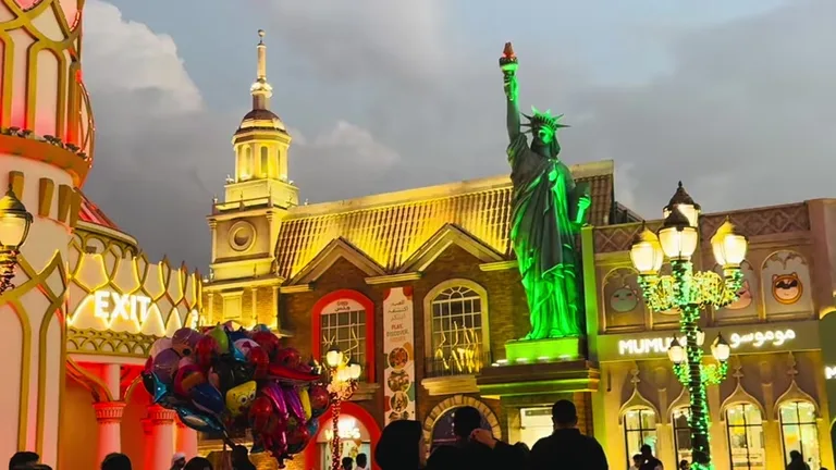 Реплика статуи Свободы с зеленой подсветкой и праздничные шары на территории комплекса Вид на Глобал Виллидж — маршрут по знаковым местам Дубая.