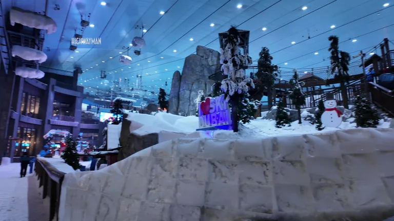 Панорамный вид на крытый комплекс Ski Dubai со снеговиком, соснами и декоративным звездным небом.