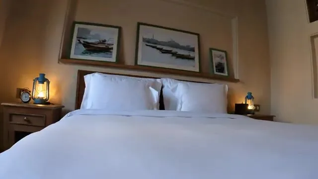 Интерьер гостиничного номера в Al Seef Heritage Hotel с традиционными фонарями и эскизами лодок.