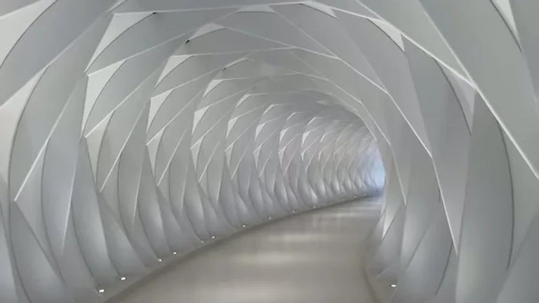 Футуристический белый коридор с геометрическими рёбрами и подсветкой пола