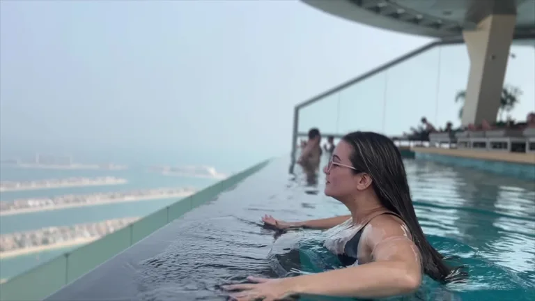 Вид на остров Пальм-Джумейра из панорамного бассейна Aura Skypool во время заката.