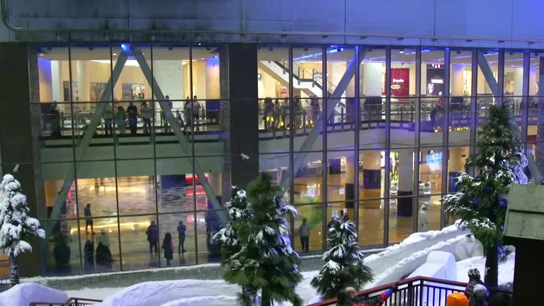 Вид из заснеженного парка Ski Dubai через большие стеклянные окна на галерею Mall of the Emirates.