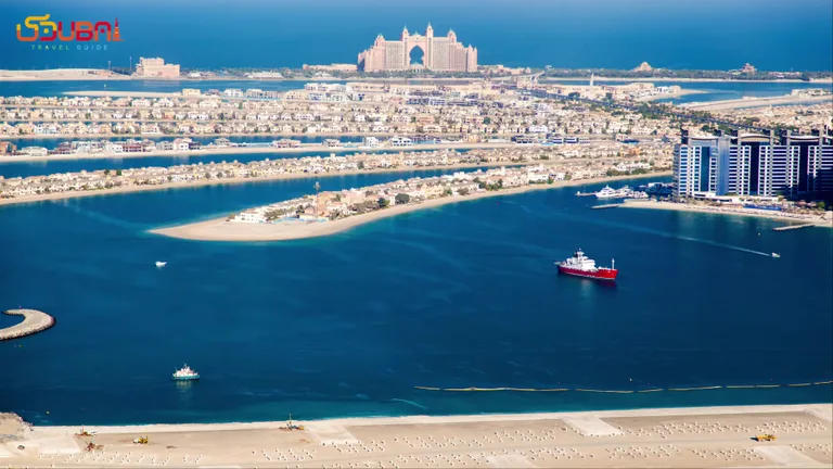 Вид сверху на курортный комплекс Atlantis The Palm и красную лодку на воде.