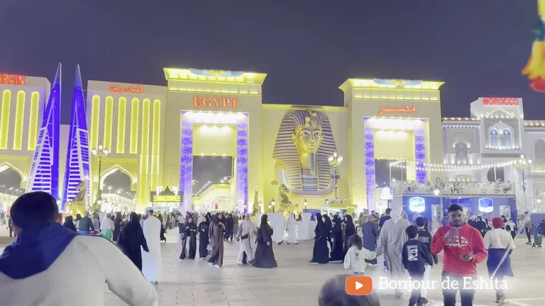 Вход в павильон Египта в Global Village, украшенный масштабной золотой головой фараона и яркими колоннами.