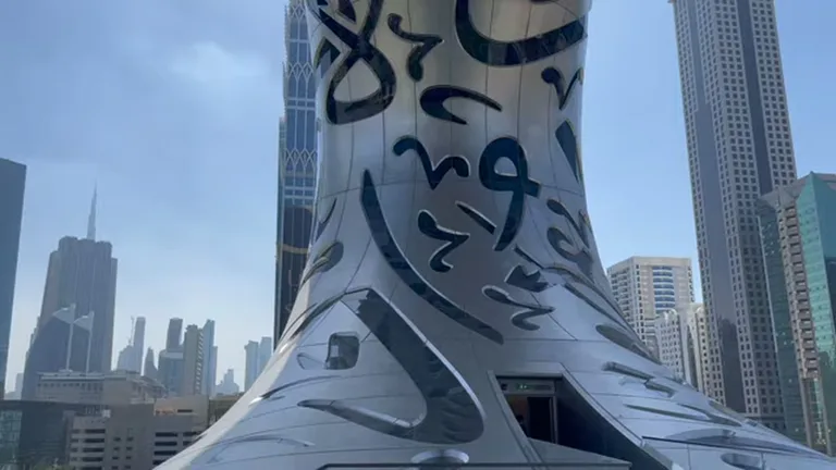 Фасад Музея Будущего с арабской каллиграфией на фоне небоскрёбов Дубая